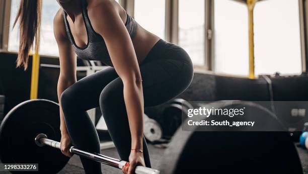fit woman exercising with weights in gym - deadlift stock pictures, royalty-free photos & images