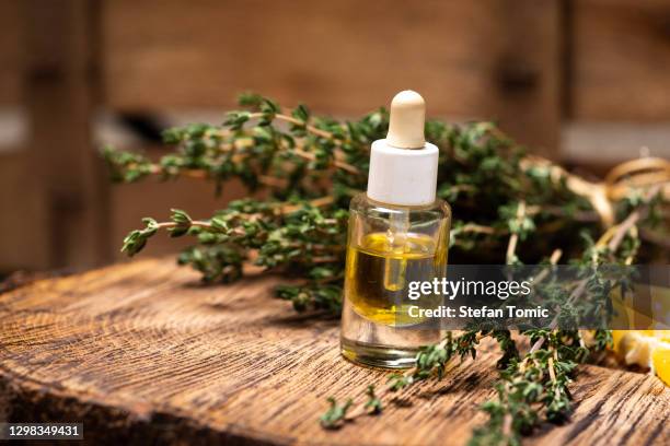 fresh garden thyme essential oil and herb on a rustic table - thyme stock pictures, royalty-free photos & images