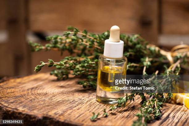 färsk trädgård timjan eterisk olja och ört på ett rustikt bord - essential oil bildbanksfoton och bilder