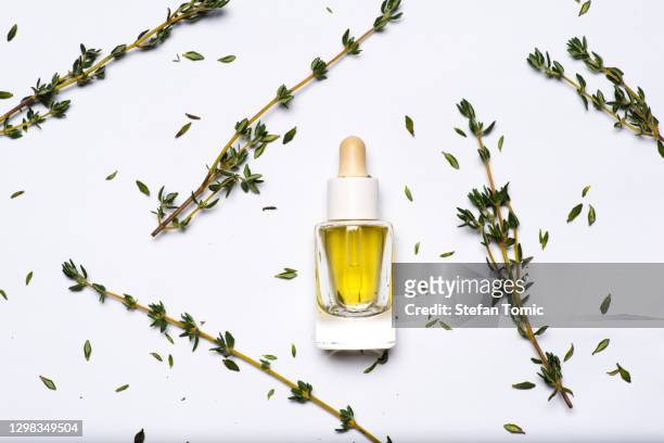 fresh garden thyme herb and essential oil on white background - thyme stock pictures, royalty-free photos & images