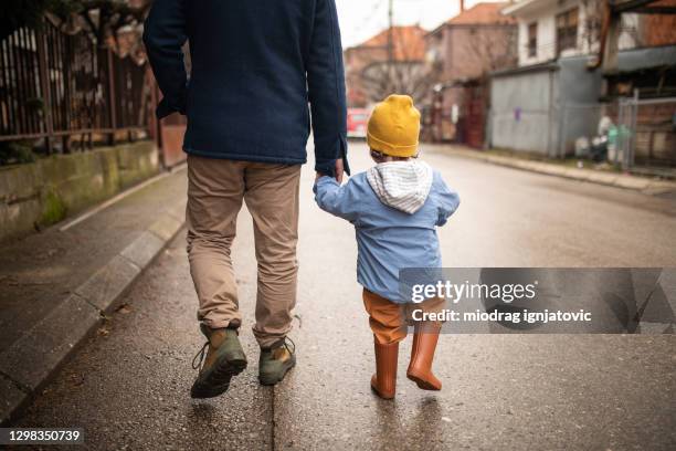 father and son in a walk during autumn day - baby-winter-clothes stock pictures, royalty-free photos & images