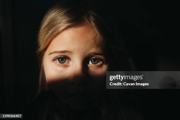 little girl's eyes in bright light with black background - black eye 個照片及圖片檔