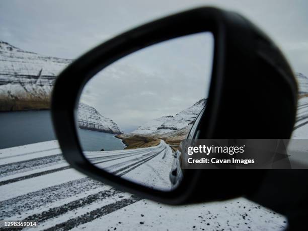 side mirror of car with view of snowy road in the faroe islands - side view mirror foto e immagini stock