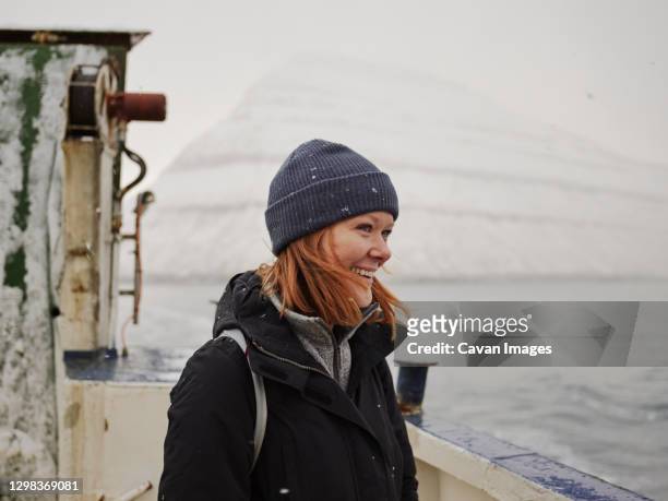woman on ferry looking out to mountains in the faroe islands - îles féroé photos et images de collection