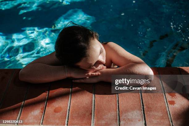 tween girl resting head on the side of a swimming pool - colorado springs stock pictures, royalty-free photos & images