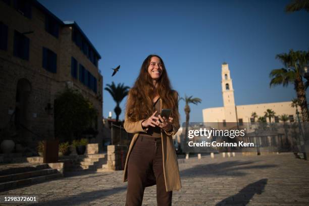 woman uses phone to navigate in old city - israeli ethnicity bildbanksfoton och bilder