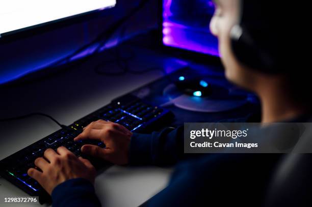 close-up on the hands of the gamer playing in the video game on a keyboard - esports foto e immagini stock