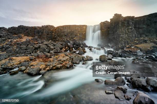 cliff with waterfall against sunrise sky - thingvellir stock pictures, royalty-free photos & images