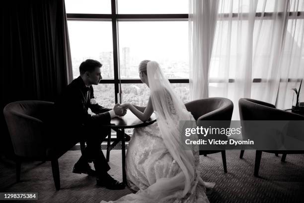 tender newlyweds in the spacious dining room - noivo papel em casamento imagens e fotografias de stock