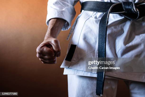 unrecognizable karateka with black belt in firm position - kickboxing gloves stock pictures, royalty-free photos & images