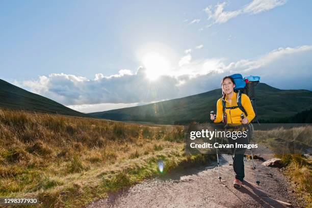 female hiker walking up towards pen y fan in wales - welsh hills stock pictures, royalty-free photos & images