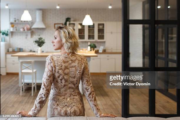beautiful adult blonde in her stylish kitchen - lace dress stock pictures, royalty-free photos & images