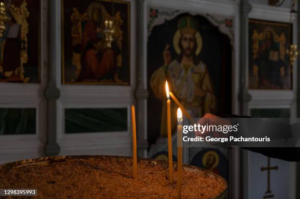 lighting a candle inside a greek orthodox church - igreja ortodoxa - fotografias e filmes do acervo