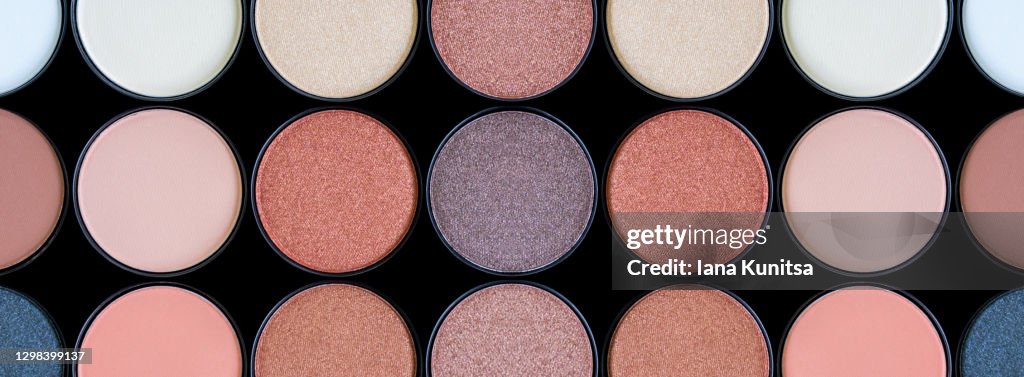 Beautiful colorful eyeshadow palette. Tool for makeup artist. Decorative cosmetic products. Brown eye shadow on black background isolated. Beauty salon. Trendy contouring beige make up. Banner.