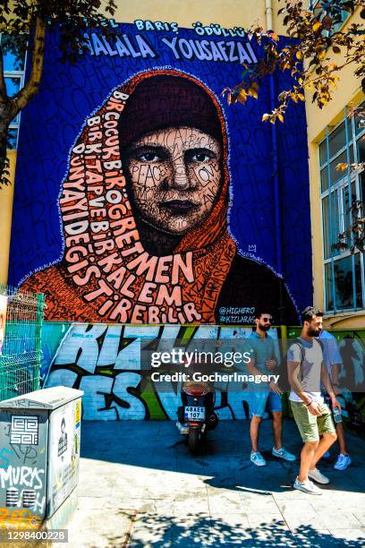 People walk past a mural depicting Pakistani activist and the youngest Nobel Prize laureate Malala Yousafzai in Istanbul, Turkey.