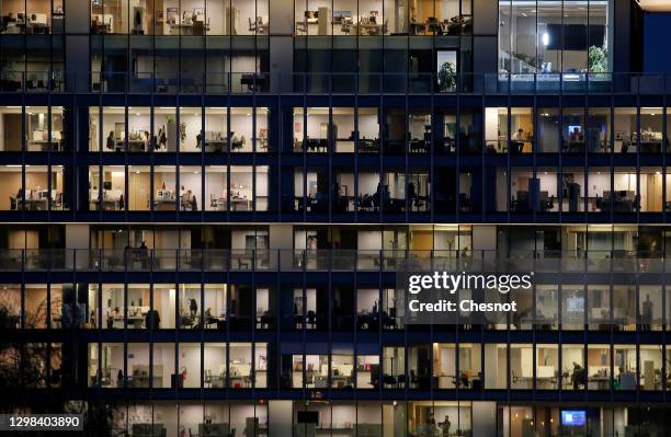 Nearly empty spaces are illuminated in skyscrapers at night after the 6 pm city-wide night time curfew in the La Defense business district during the...