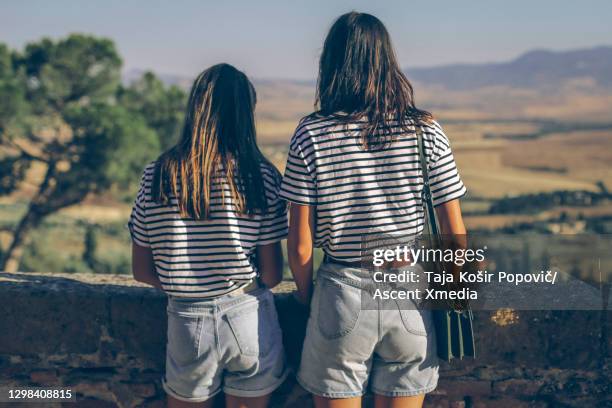 two young girls look out at pastoral scene - mesma roupa imagens e fotografias de stock