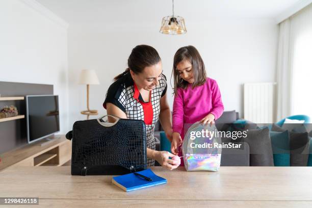 mother going to work and her little daughter who goes to school prepare their bags together - closing laptop stock pictures, royalty-free photos & images