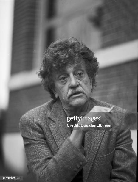 View of American author Kurt Vonnegut Jr as he smokes a cigarette outside the Michigan State University Student Union, East Lansing, Michigan, April...