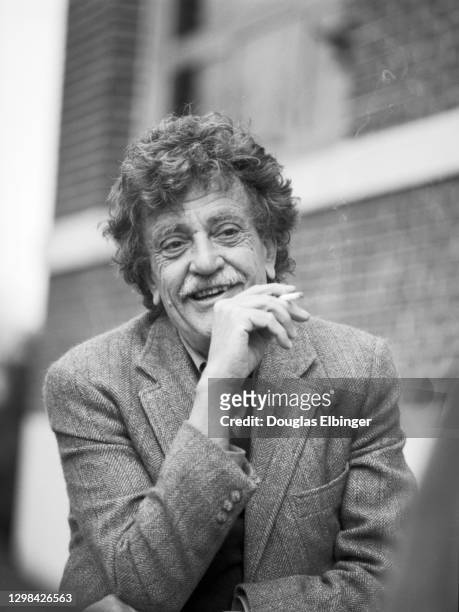 View of American author Kurt Vonnegut Jr as he smokes a cigarette outside the Michigan State University Student Union, East Lansing, Michigan, April...
