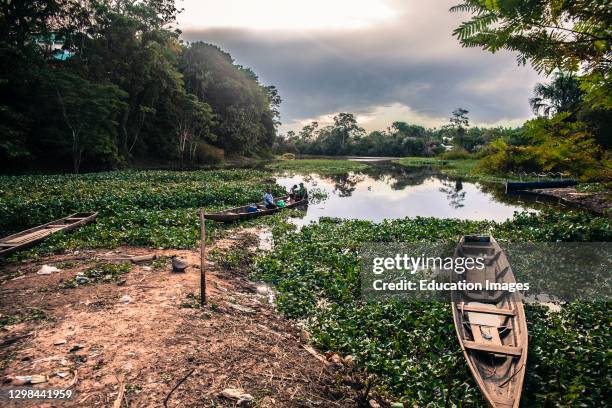 Tukano family rests in their canoe at sunset in downtown Sao Gabriel.