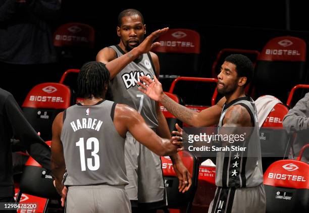 James Harden, Kevin Durant, and Kyrie Irving of the Brooklyn Nets high-five after coming off the court during the second half against the Miami Heat...