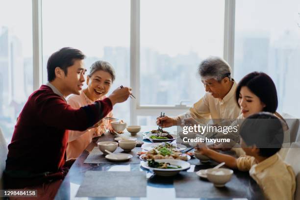 asiatische chinesische familie bei einem wiedersehen abendessen zu hause - chinese family dinner stock-fotos und bilder