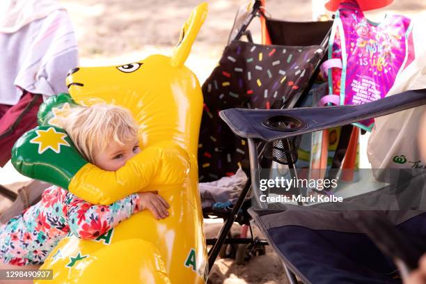 Ava Brink hugs an inflatable boxing kangaroo under her family's sun shade at the Nepean River Reserve in Menangle Park on January 26, 2021 in Sydney,...