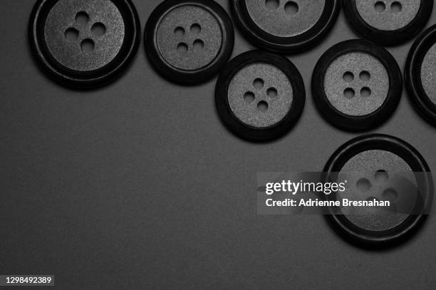 black buttons on black background - button craft stock pictures, royalty-free photos & images