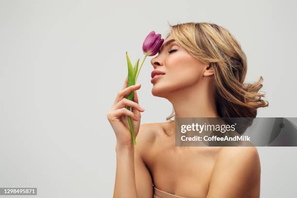 hermosa mujer con una flor - mujeres hermosas fotografías e imágenes de stock