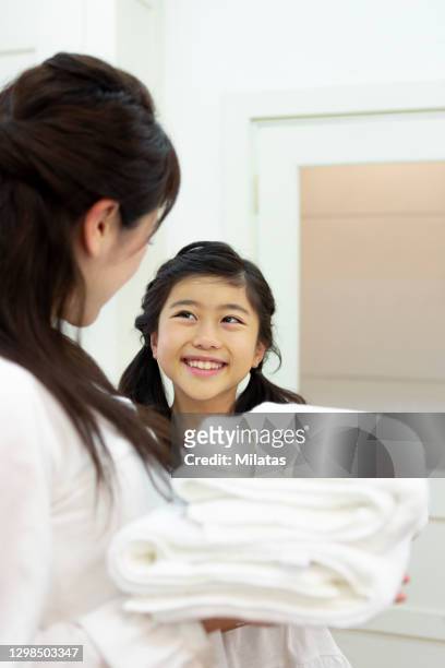 parent and child standing with laundry - stereotypical housewife stock-fotos und bilder