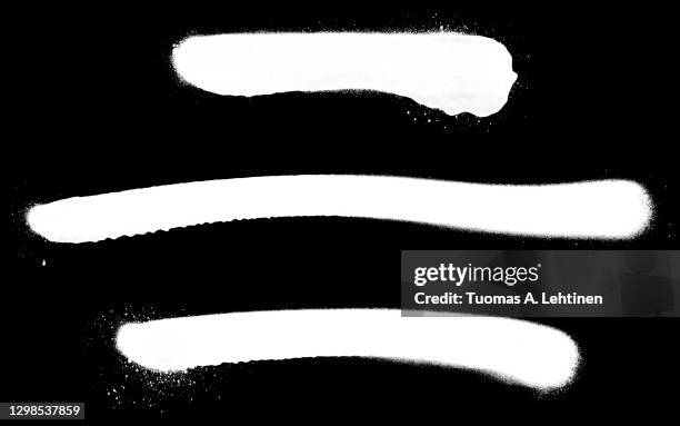 close-up of three white spray paint lines, isolated on black background. - graffity stock-fotos und bilder