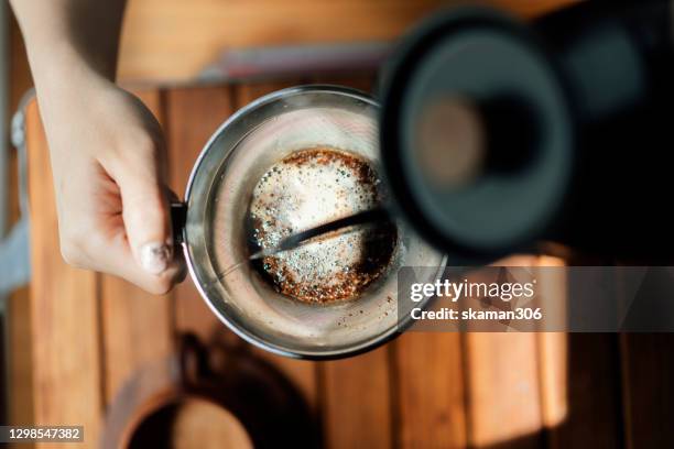 wide agle of solo asian young man adult grinder coffee bean for brewing hot espresso at home - steeping stock pictures, royalty-free photos & images