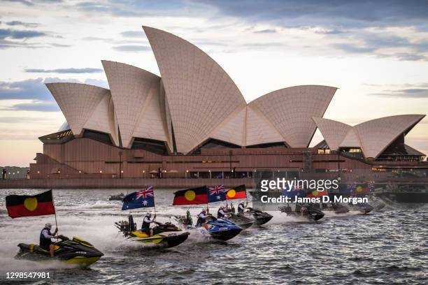 Jet skies displaying Australian and Aboriginal flags travel in front of the Sydney Opera House during an Australia Day show on January 26, 2021 in...