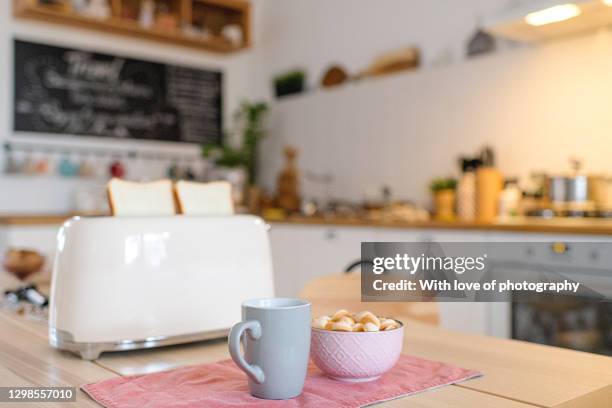 modern white kitchen details, scandinavian kitchen interior with a breakfast on the table with toaster and cup - kitchen table stock-fotos und bilder