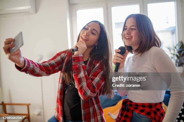 using smart phone to film a music video in living room - girl singing stock pictures, royalty-free photos & images