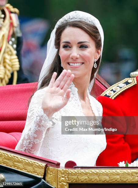 Catherine, Duchess of Cambridge travels down The Mall, on route to Buckingham Palace, in the 1902 State Landau horse drawn carriage following her and...