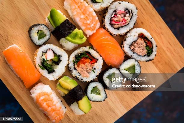 selección de sushi fresco en tablero de madera - nigiri fotografías e imágenes de stock