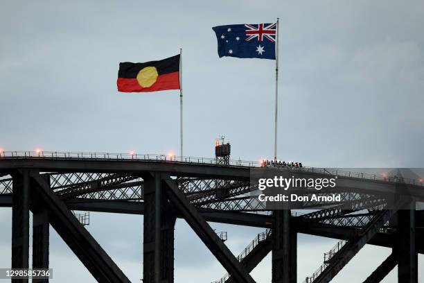 The Aboriginal and Australian flags are seen flying atop the Sydney Harbour Bridge during Australia Day Live 2021 at Sydney Opera House on January...