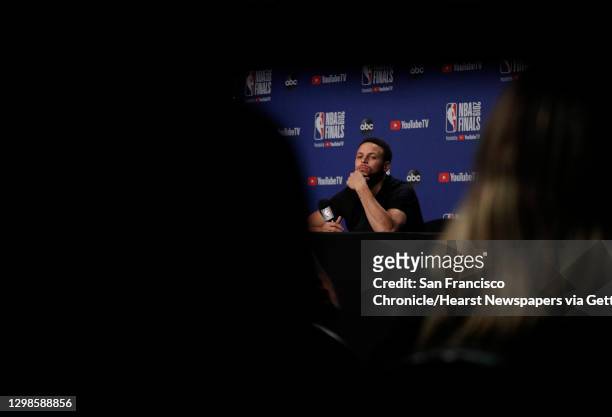 Stephen Curry listens to a reporter as he answers questions from the press as the Golden State Warriors and Toronto Raptors practiced before Game 5...