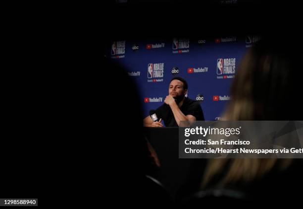 Stephen Curry listens to a reporter as he answers questions from the press as the Golden State Warriors and Toronto Raptors practiced before Game 5...