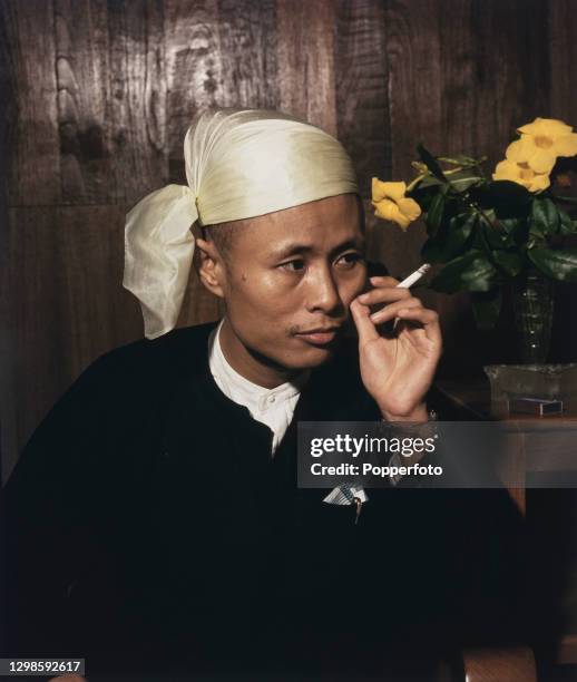 Burmese politician and revolutionary Aung San , Premier of the British Crown Colony of Burma, smokes a cigarette at home in Rangoon , Burma in July...