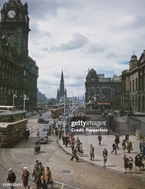 View of trams, cars and pedestrians making their way along Princes Street in Edinburgh, Scotland during the Edinburgh Festival in August 1947. The...