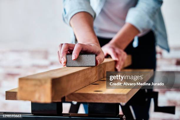 detail view of an unrecognizable woman sanding a piece of wood. concept of do-it-yourself, woodworking and carpentry at home. - sandpapper bildbanksfoton och bilder