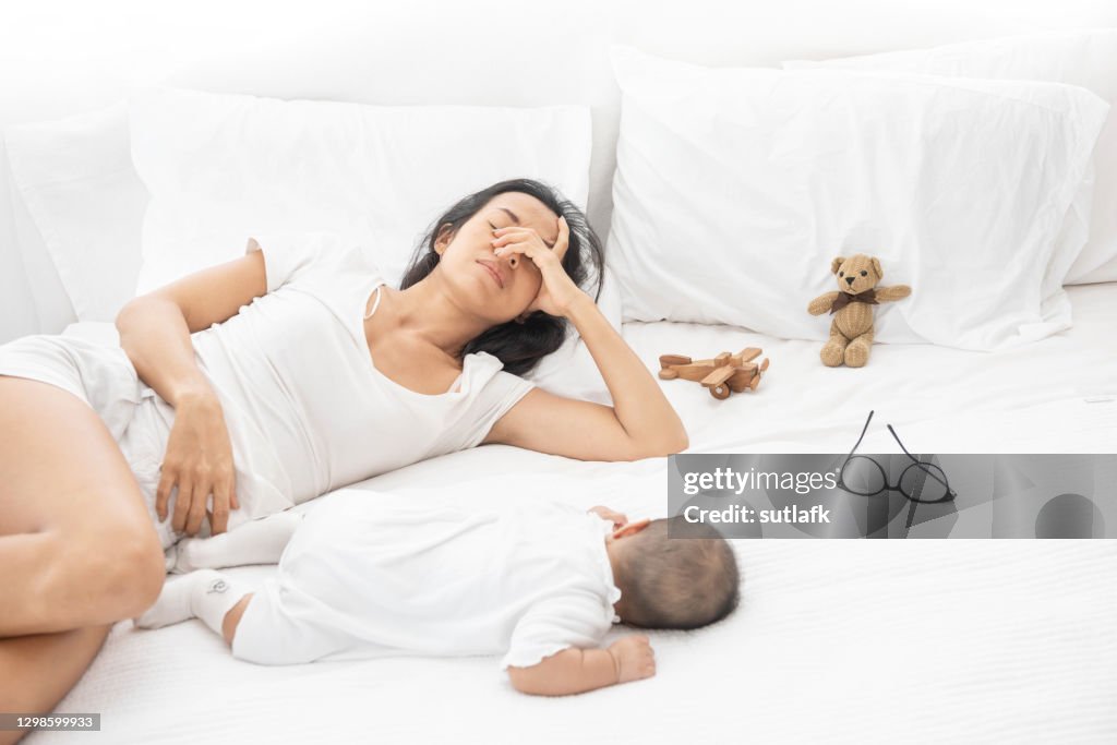 Tired Exhausted Mother Sleeping Sleep With Baby On White Bed