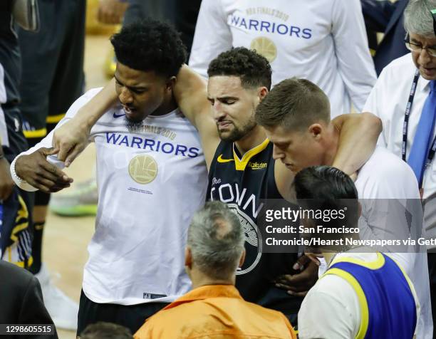 Golden State Warriors Klay Thompson is helped off the court by Jordan Bell and Jonas Jerebko in the third quarter during game 6 of the NBA Finals...