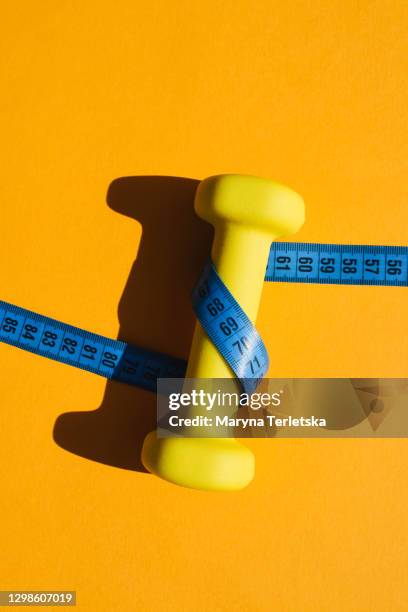 yellow kettlebell for sports exercise with a centimeter on a yellow background. - hand weight stock pictures, royalty-free photos & images