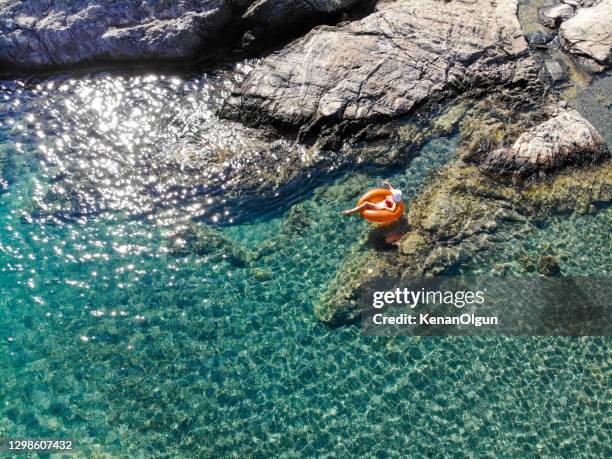 beautiful woman relaxing on inflatable mattress in sea. - bodrum stock pictures, royalty-free photos & images