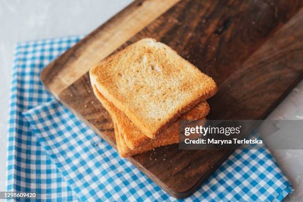 fried croutons with crumbs on a wooden board. - geroosterd brood stockfoto's en -beelden