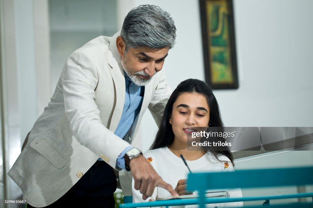 Man with girl writing in diary